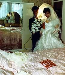 Groom shows bed to bride