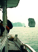 Cruise boat approaches mountains.