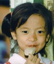 Chinese girl enjoys ice lolly.