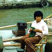 Woman knits on canal barge